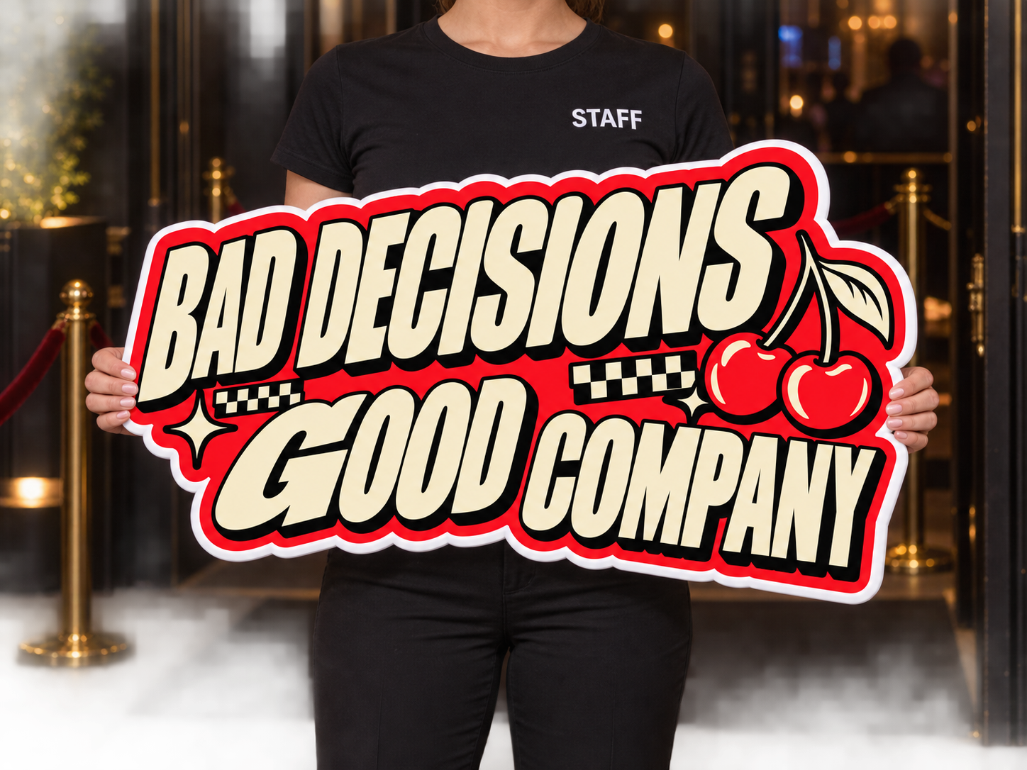 Bottle-service host holding a Bad Decisions Good Company custom foam sign in a nightclub, face out of frame