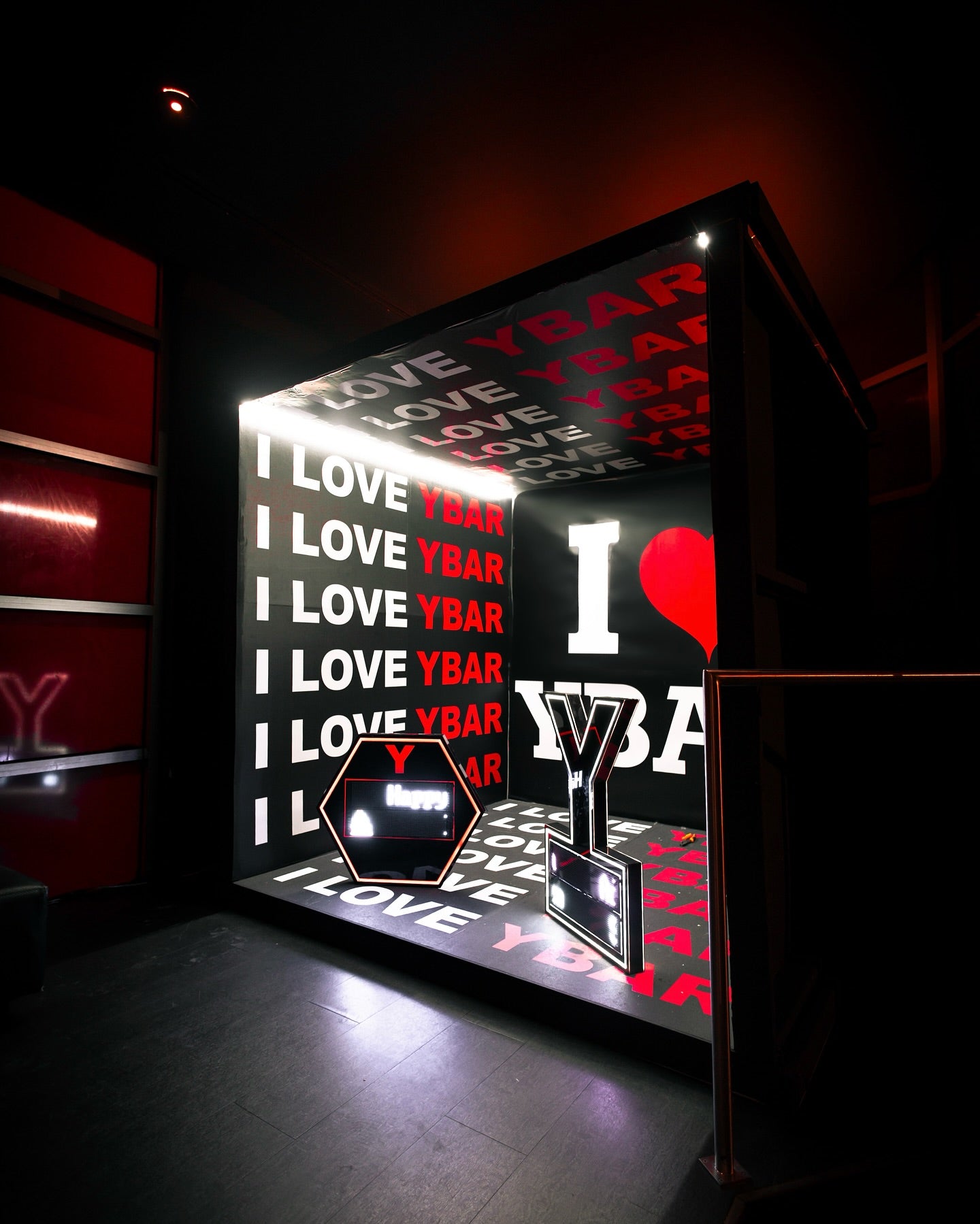 Custom eight-foot photo booth installation with printed walls, floor and illuminated details in a nightclub.